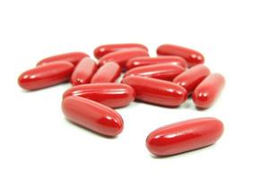 comprimidos vermelhos isolados no fundo branco foto