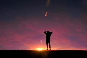 homem trekking na montanha com um fundo por do sol no verão foto