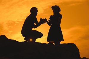 casal jovem feliz juntos contra o belo pôr do sol. liberdade, foto