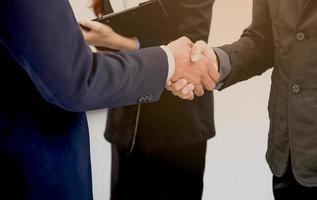 dois empresário confiante apertaram as mãos durante as reuniões de escritório. foto