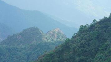 as belas paisagens das montanhas com a floresta verde e o penhasco rochoso em erupção como pano de fundo na zona rural da china foto