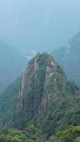 as belas paisagens das montanhas com a floresta verde e o penhasco rochoso em erupção como pano de fundo na zona rural da china foto