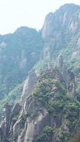 as belas paisagens das montanhas com a floresta verde e o penhasco rochoso em erupção como pano de fundo na zona rural da china foto