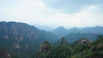 as belas paisagens das montanhas com a floresta verde e o penhasco rochoso em erupção como pano de fundo na zona rural da china foto