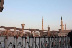 medina, arábia saudita, outubro de 2022 - uma bela vista diurna dos minaretes masjid al nabawi e guarda-chuvas ou dosséis eletrônicos. foto