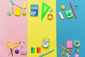 vários artigos de papelaria para a escola em um fundo multicolorido. de volta à escola foto