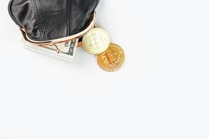 uma carteira preta aberta com moedas de dinheiro, dólares e bitcoin em um fundo branco. foto