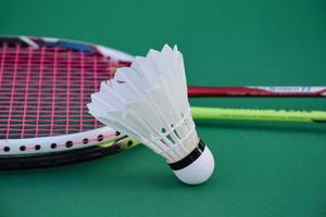 peteca de badminton branca creme e raquete no chão na quadra de badminton indoor, espaço de cópia, foco suave e seletivo em petecas. foto