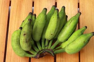 frutas de banana verde em fundo de madeira foto