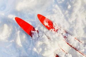 dicas de esquis vermelhos na neve ensolarada foto