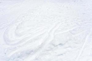 campo de neve com pistas de esqui e caminhos na neve foto