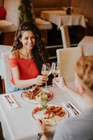 jovem casal almoçando com vinho branco no restaurante