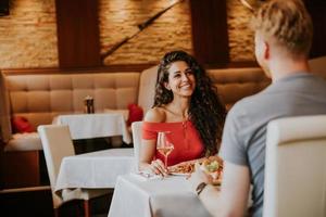 jovem casal almoçando com vinho branco no restaurante