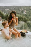 jovem casal desfrutando na banheira de hidromassagem ao ar livre de férias foto