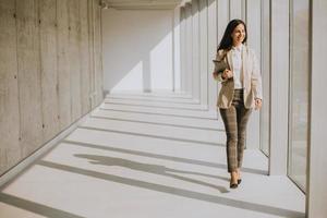 jovem empresária andando no corredor do escritório moderno foto