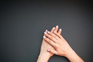 mãos de mulher com manicure rosa pastel foto