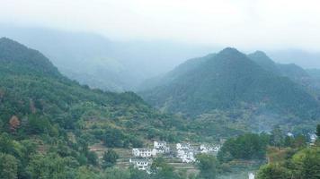 a bela vista da vila tradicional chinesa com a arquitetura clássica e árvores verdes frescas como pano de fundo foto