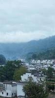 a bela vista da vila tradicional chinesa com a arquitetura clássica e árvores verdes frescas como pano de fundo foto