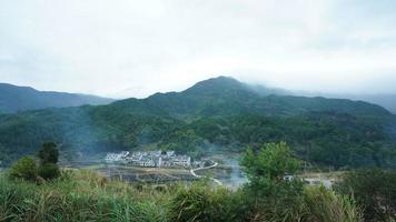 a bela vista da vila tradicional chinesa com a arquitetura clássica e árvores verdes frescas como pano de fundo foto