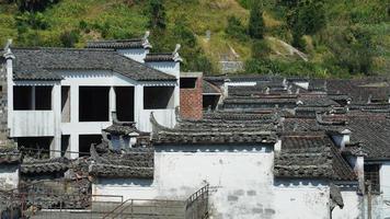 a bela vista da vila tradicional chinesa com a arquitetura clássica e árvores verdes frescas como pano de fundo foto