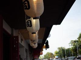 lanterna japonesa pendurada na frente do restaurante japonês, texto japonês na lanterna é comida japonesa de sushi. foto