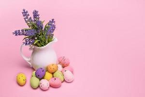 ovos coloridos de páscoa estão ao lado de um buquê de flores em um vaso, cartão de páscoa com espaço para texto foto