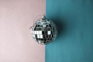 bola de discoteca de espelho de prata clube musical pequeno vidro redondo inverno brilhante decorativa linda bola de natal festiva de natal, brinquedo de natal colado em glitter em um fundo roxo rosa cinza foto