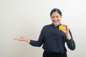 mulher asiática segurando um cartão de crédito com fundo branco foto