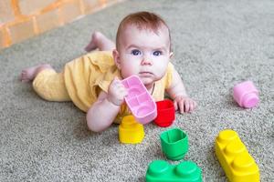 retrato sincero do estilo de vida da menina. criança brincando com construtor colorido de plástico macio. foto