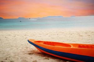 barco de caiaque laranja na praia foto