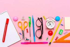 caderno escolar e material de escritório em um fundo rosa. de volta à escola foto