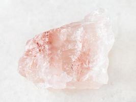 cristal áspero de pedra preciosa de quartzo rosa em branco foto
