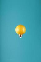 limão como uma lâmpada em levitação sobre um fundo azul. a ideia conceitual foto