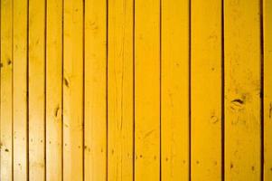 a textura de placas verticais de madeira natural com pontos pintados de tinta amarela brilhante. o fundo foto