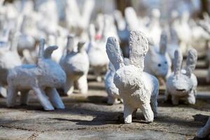 estátuas de coelho branco feitas de gesso na exposição de arte ao ar livre, lebres brancas engraçadas na rua foto