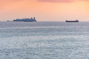 navios de carga e barcaça ao pôr do sol. incrível vista do mar à noite, vista de viagem de tirar o fôlego, copie o espaço. ancoradouro para navios foto