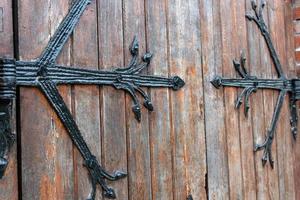 padrão de porta forjado, decorativo. antiga entrada vintage, enorme porta de madeira pesada da igreja ou catedral. foto