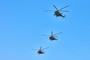 três helicópteros militares voando no céu azul realizando voo de demonstração, show aéreo, espaço de cópia foto