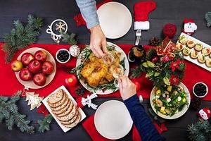 peru assado. ceia de Natal. a mesa de natal é servida com um peru, decorado com enfeites brilhantes e velas. frango frito, mesa. jantar em família. vista do topo foto