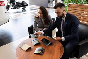 uma jovem está determinada com a decoração interior de um carro novo ao comprá-lo em uma concessionária de carros foto