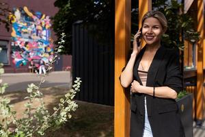 mulher trabalhadora por conta própria falando ao telefone na cidade foto