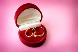 uma linda caixa de presente festiva vermelha de veludo para dois noivados, alianças de casamento com ouro precioso anéis redondos de pilha preciosa. proposta de casamento conceito, casamento, noivado