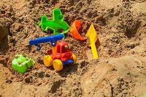 caixa de areia infantil no playground para jogos com brinquedos para crianças de caminhão, carro, escavadeira, aparadores de areia com espátula foto