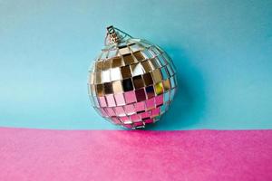 bola de discoteca de espelho de prata clube musical pequeno vidro redondo inverno brilhante decorativa linda bola de natal festiva de natal, brinquedo de natal colado em glitter em um fundo roxo rosa cinza foto