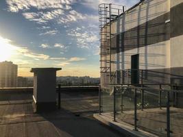 varanda no telhado da casa. estruturas metálicas para cercar outras pessoas. própria área de churrasco no telhado. ao lado da casa há uma escada para acesso ao telhado de um vizinho foto