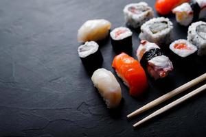 comida de sushi japonesa. maki ands rolls com atum, salmão, camarão, caranguejo e abacate. vista superior de sushis variados. foto