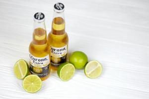 kharkov, ucrânia - 9 de dezembro de 2020 garrafas de cerveja extra corona com fatias de limão. corona produzida pelo grupo modelo com anheuser busch inbev cerveja importada mais popular dos eua foto