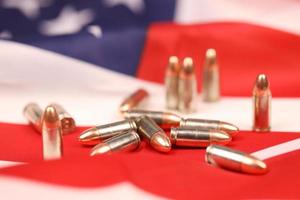 muitas balas e cartuchos amarelos de 9 mm na bandeira dos estados unidos. conceito de tráfico de armas no território dos eua ou operações especiais foto