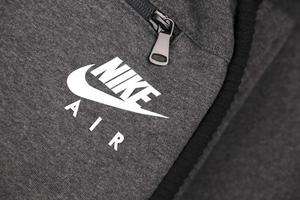 kharkov, ucrânia - 20 de dezembro de 2020 nike air logo no fragmento de roupas esportivas cinza. nike é uma empresa multinacional americana envolvida na fabricação e comercialização mundial de roupas e calçados foto