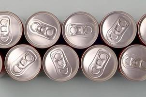 muitas novas latas de alumínio de refrigerantes ou recipientes de bebidas energéticas. conceito de fabricação de bebidas e produção em massa foto